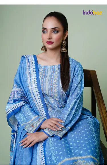 A side portrait of a woman in a bun hairstyle wearing oversized gold jhumkas with minimal makeup