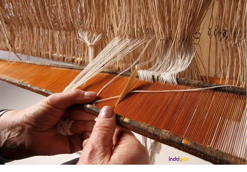 Artisanal handloom khadi being woven on a traditional loom in natural light
