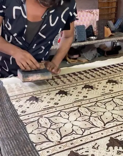 Indian artisan hand-printing Ajrakh fabric in a detailed shot